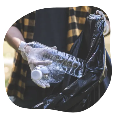 Uma mulher com cabelos brancos em pé, segurando perto da cabeça um balde escrito Temos um sonho, um mundo sem lixo, atrás dela está um fundo verde